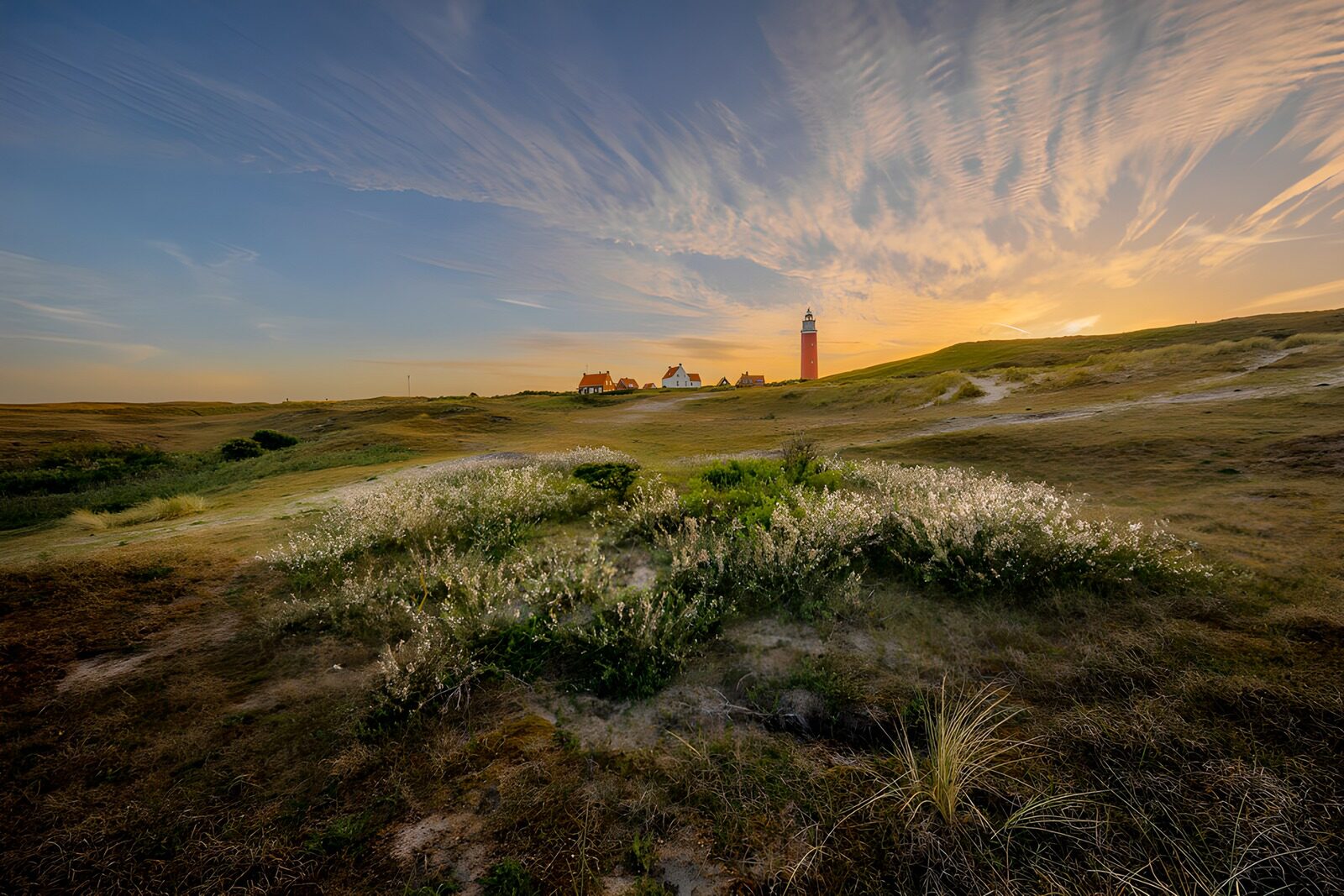 PDGIT7444239: Faro rosso tra le dune al tramonto