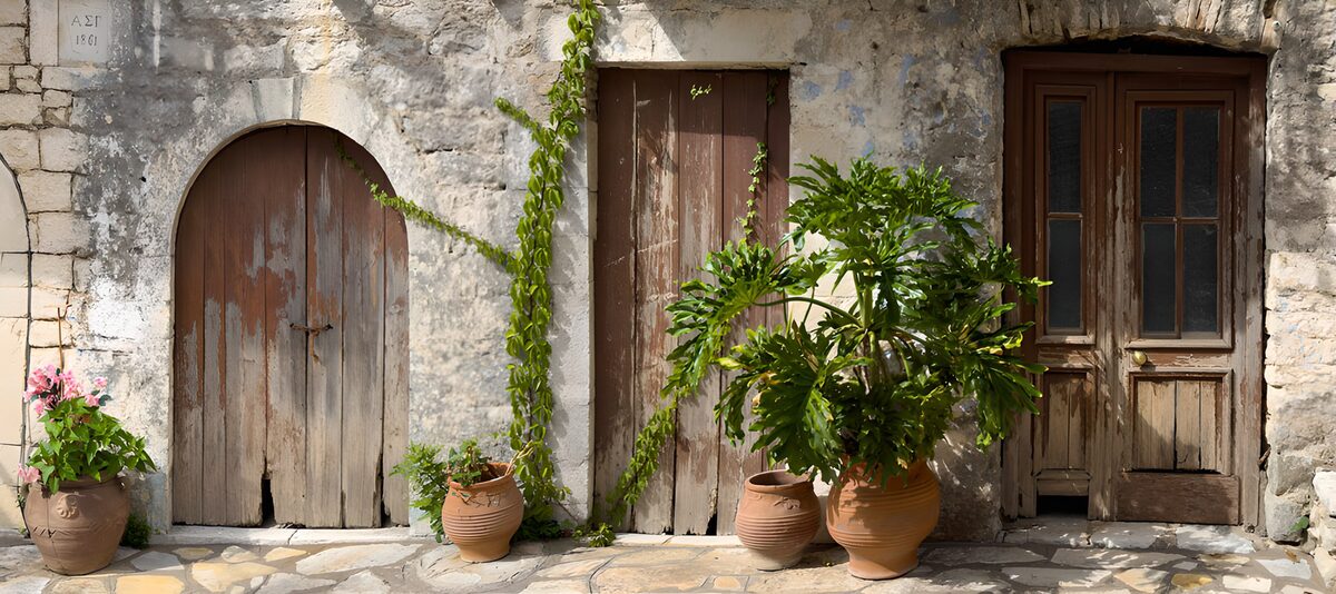 PDGIT7449814: Tre porte in legno tra pietra e vasi