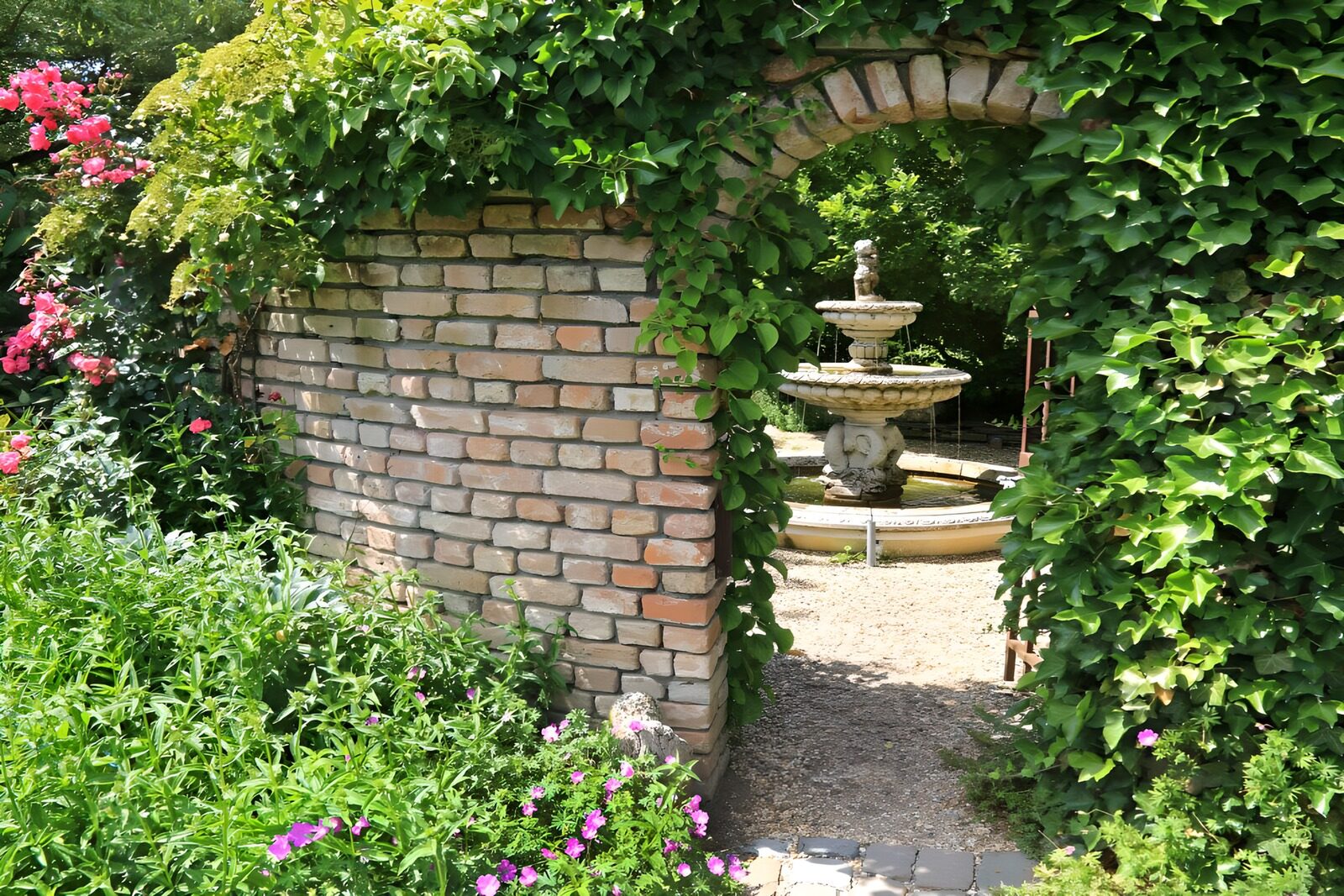 PDGIT1729552: Arco di edera e fontana in giardino