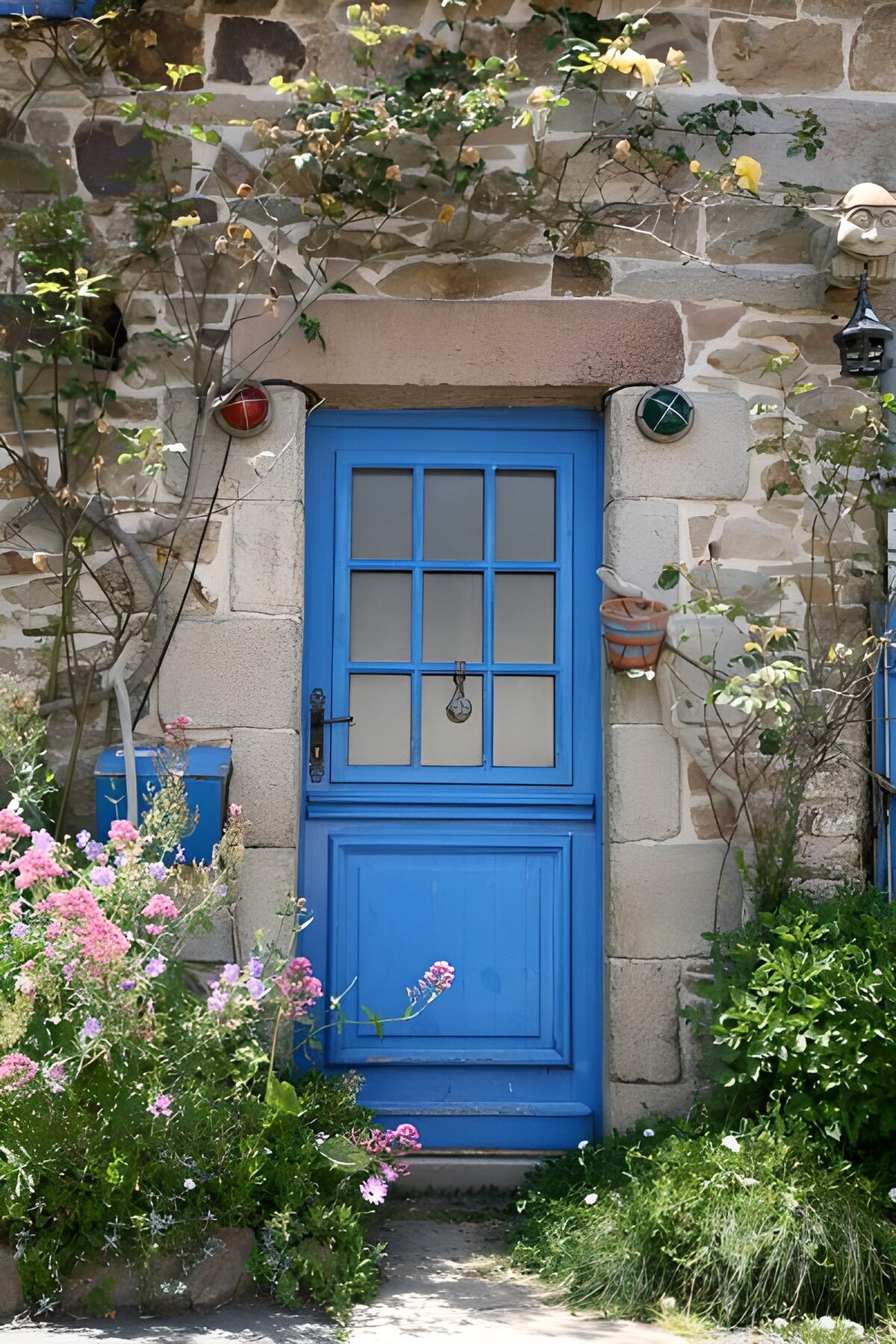 PDGIT1373549: Porta blu tra pietra e fiori