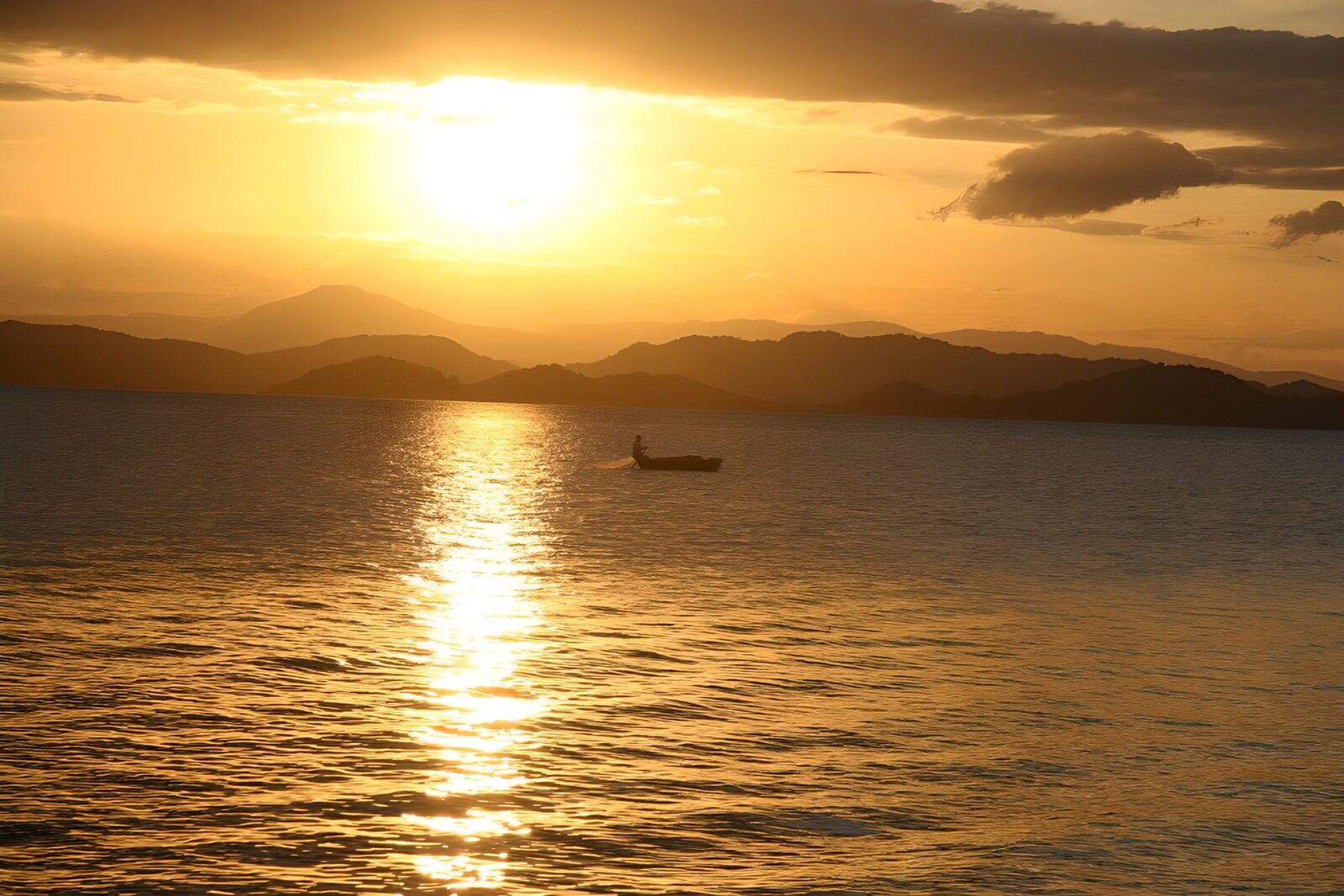 PDGIT8343482: Barca solitaria al tramonto dorato