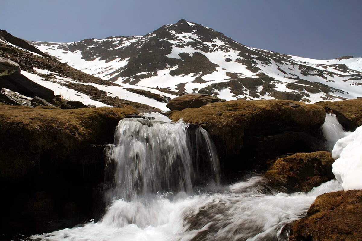 PDGIT1121328: Cascata impetuosa sotto il monte innevato