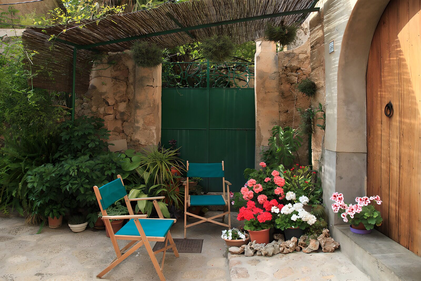 PDGIT5909962: Sedie turchesi nel cortile fiorito