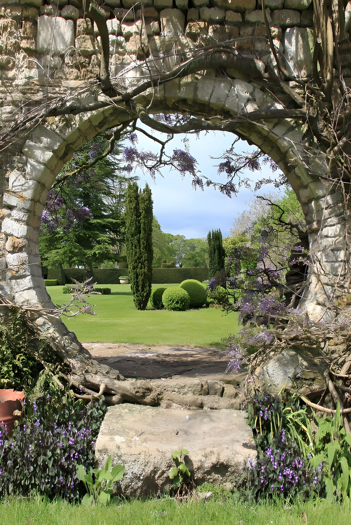 Arco in pietra sul giardino fiorito