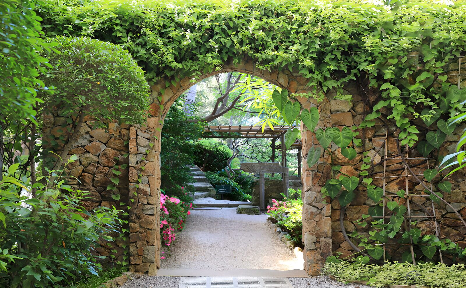 PDGIT6201421: Arco in pietra nel giardino rigoglioso