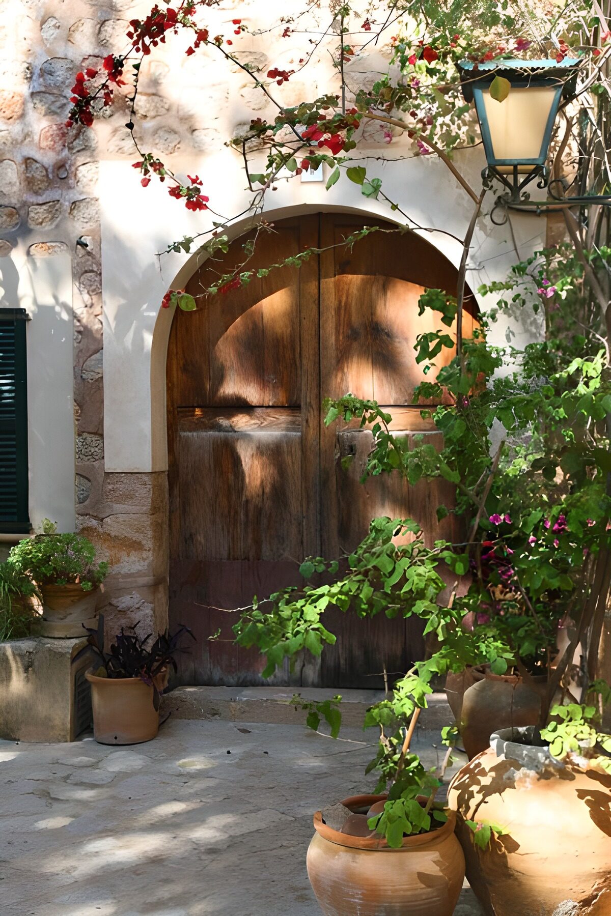 PDGIT3463538: Porta ad arco tra vasi e fiori