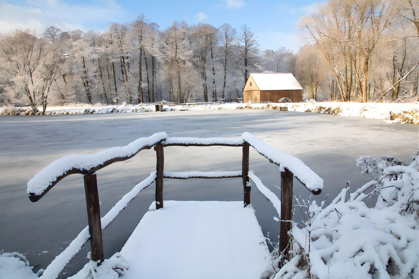 PDGIT7995578: Pontile innevato sullo stagno ghiacciato