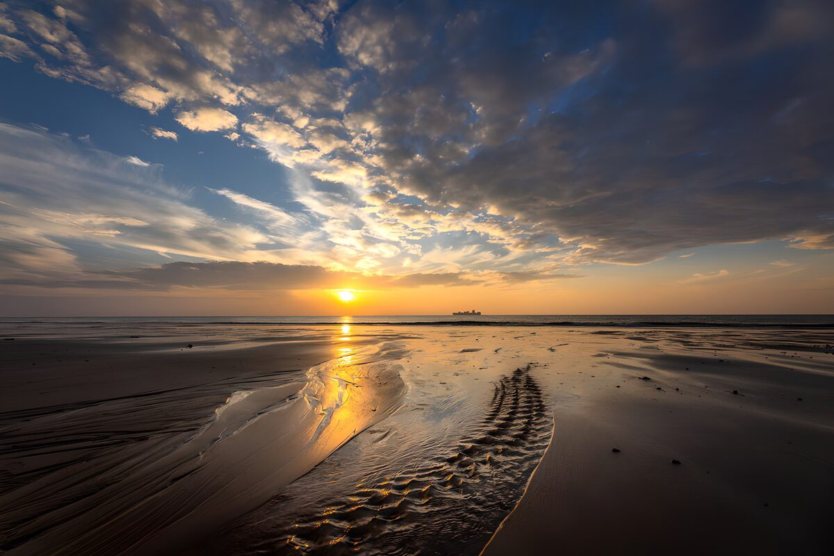 Spiaggia al tramonto tra riflessi dorati