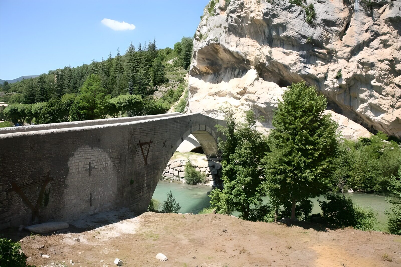 PDGIT8634421: Ponte di pietra sul fiume verde al sole