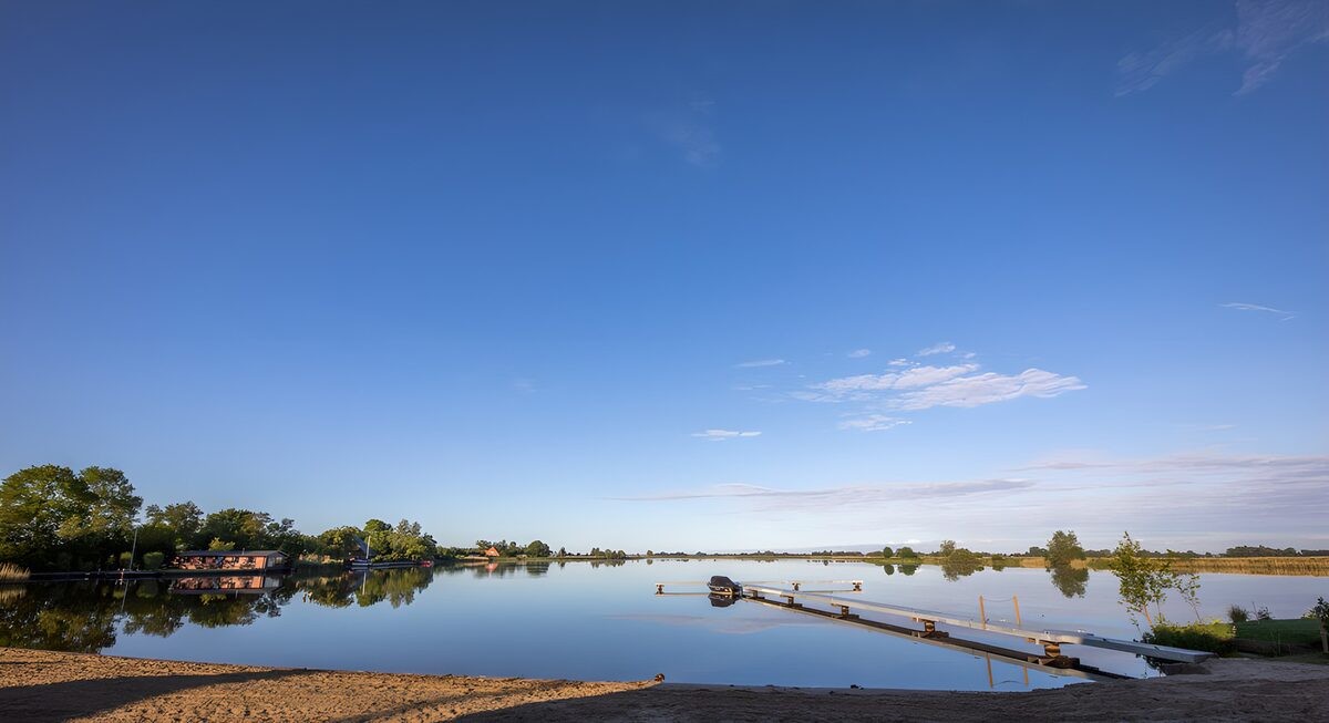 PDGIT6347486: Pontile e motoscafo sull’acqua calma