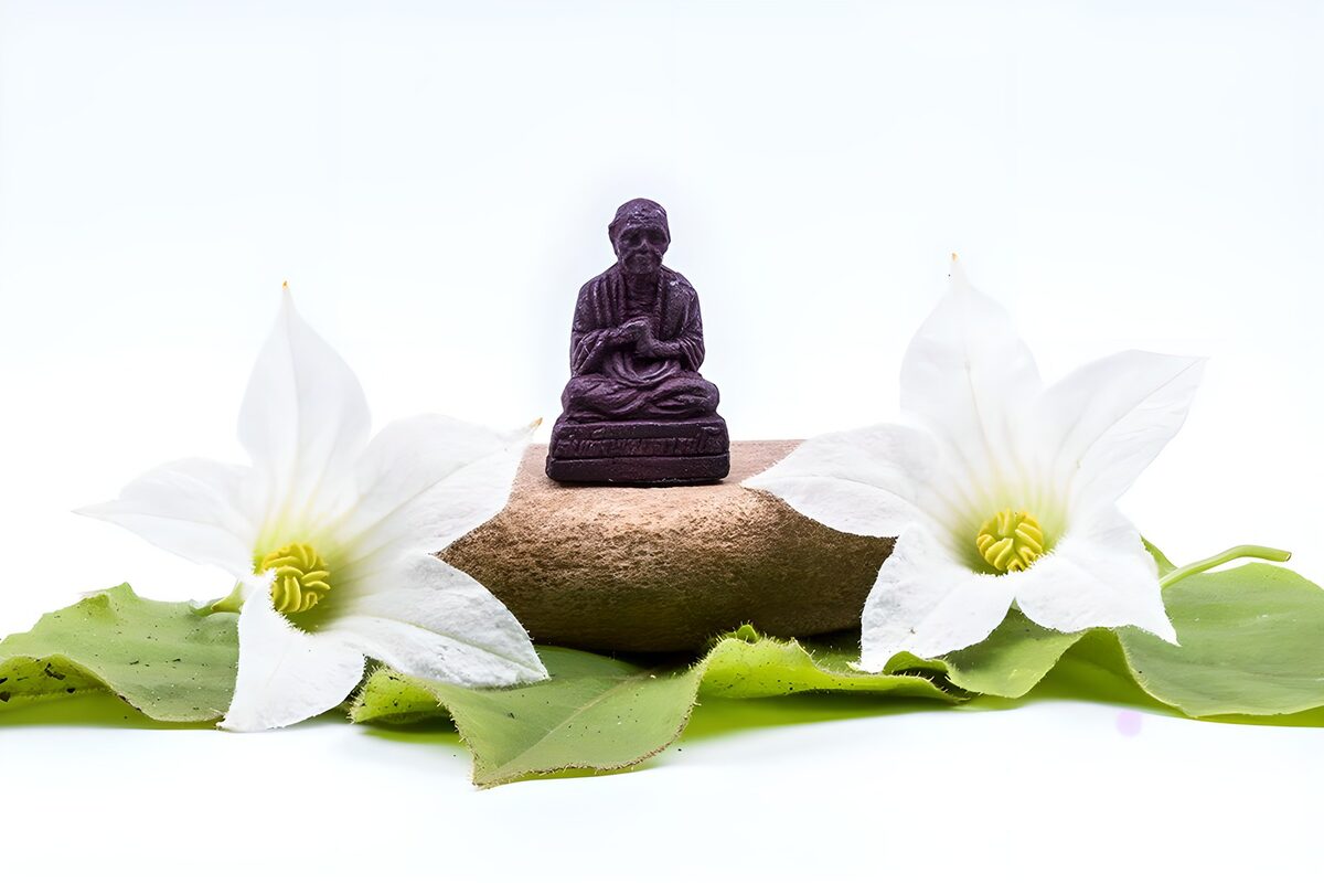 PDGIT2649558: Statuetta su pietra tra fiori bianchi