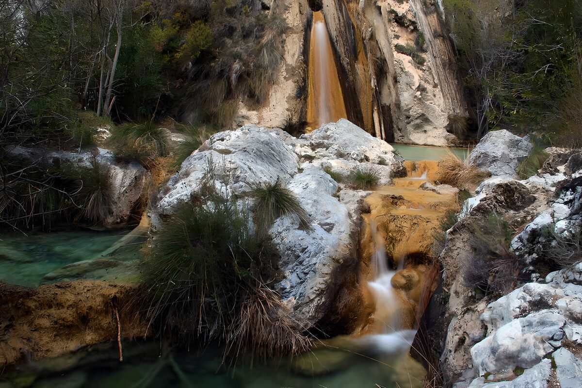 PDGIT5180361: Cascata tra rocce chiare e pozze verdi