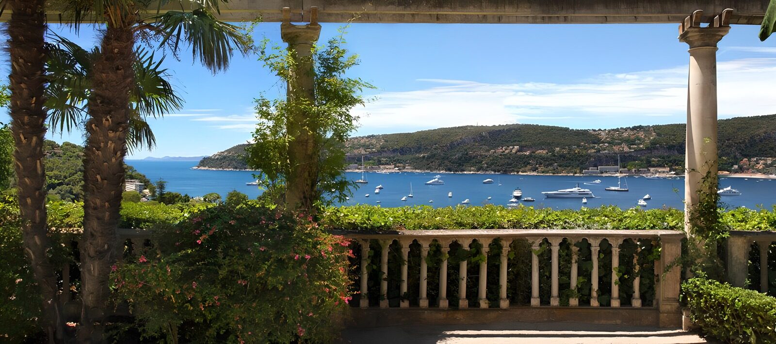 PDGIT8602095: Terrazza con palme e barche nella baia