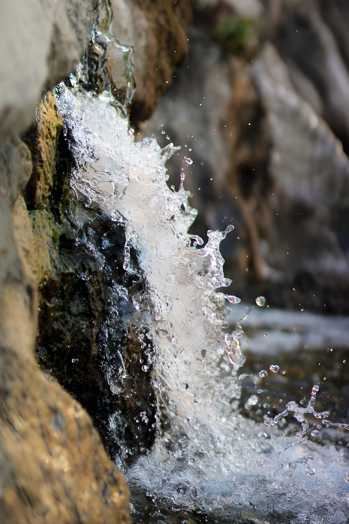 PDGIT3546684: Acqua e spruzzi sulla roccia scura