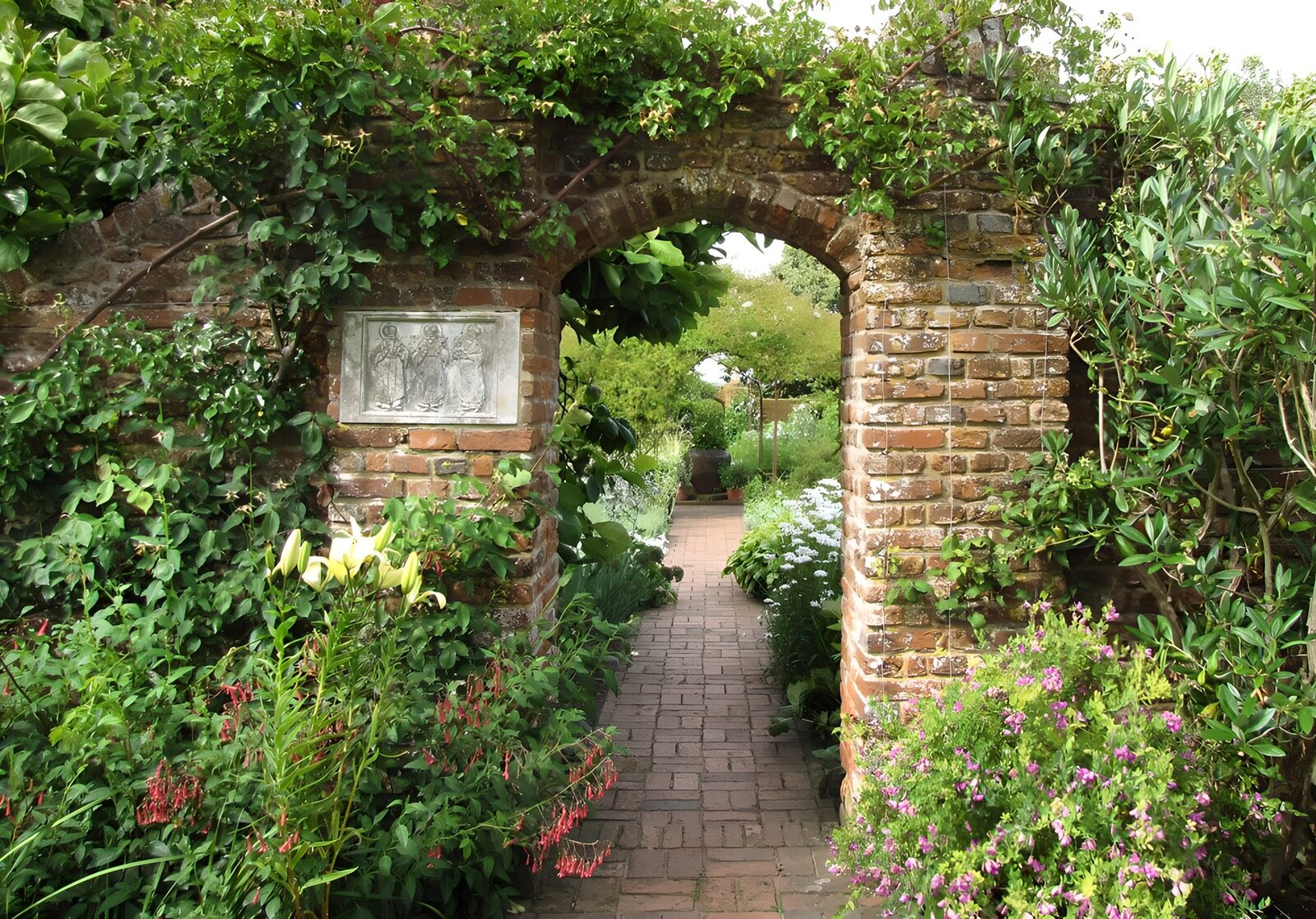 PDGIT1850494: Arco di mattoni nel giardino in fiore