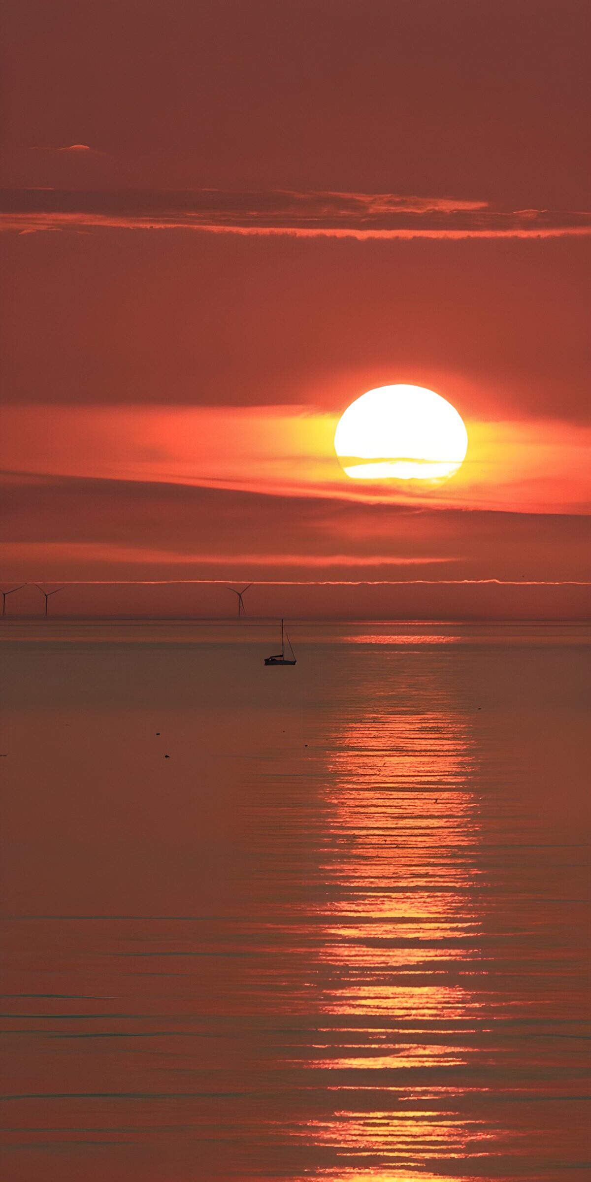 PDGIT7947442: Tramonto rosso sul mare con barca a vela