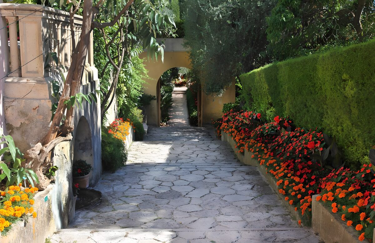 Sentiero in pietra tra fiori e ombre