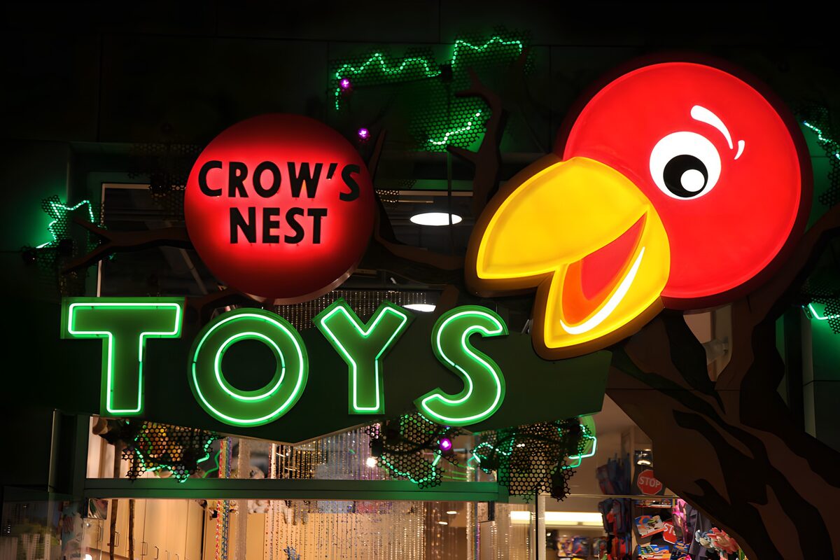 PDGIT5829315: Insegna TOYS e uccello rosso tra le luci