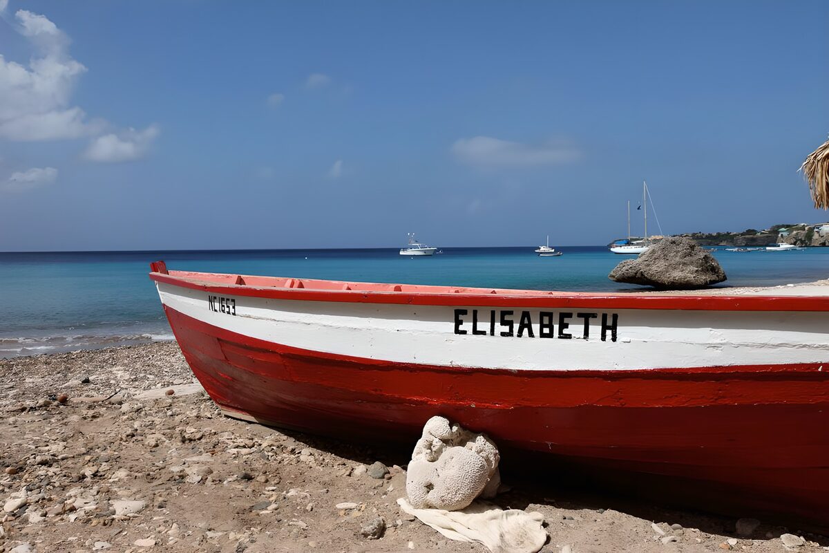PDGIT2391417: Barca rossa sulla spiaggia di ciottoli