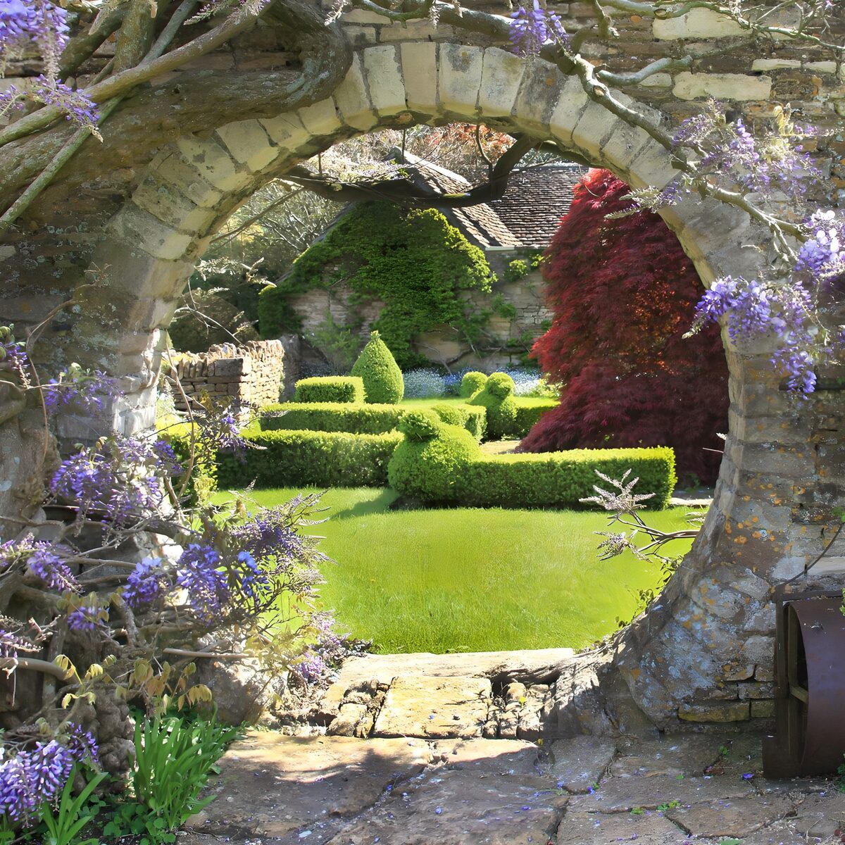 Arco in pietra sul giardino di primavera