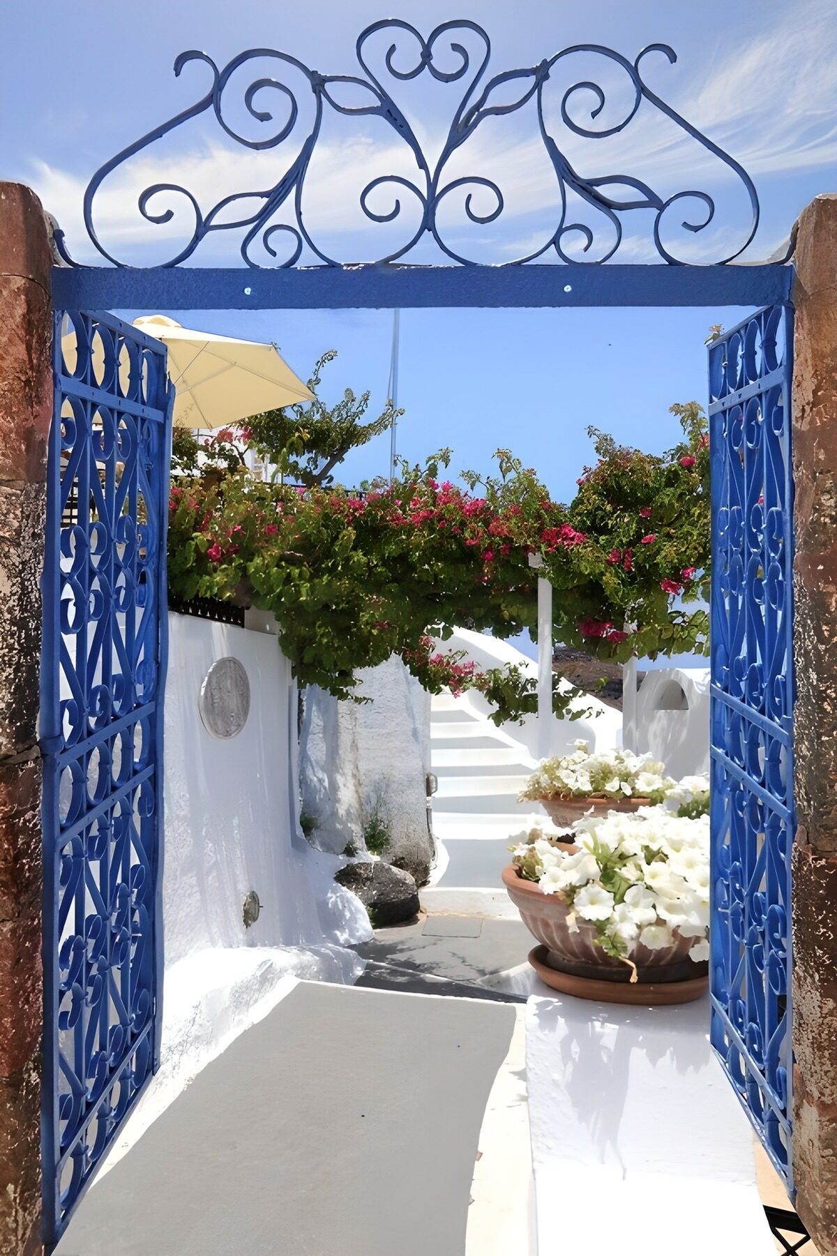 PDGIT6036895: Cancello blu su un cortile al sole