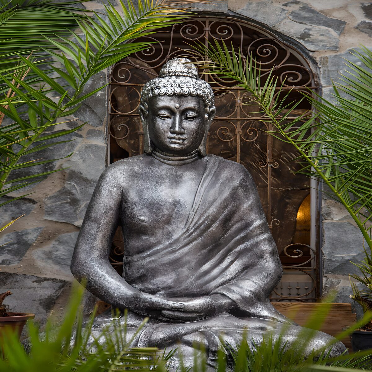 PDGIT5773575: Buddha grigio seduto tra le palme