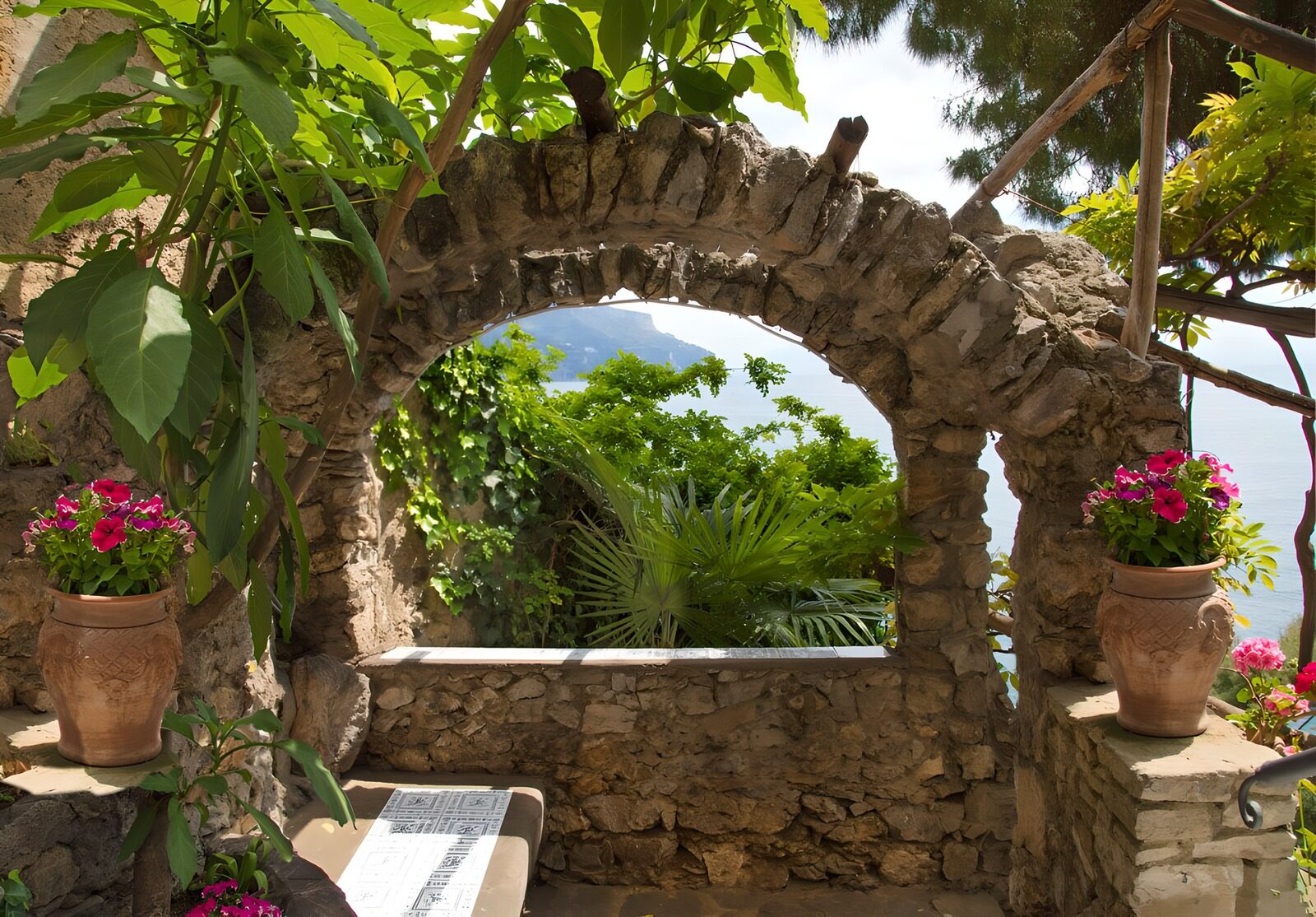 PDGIT8960377: Arco in pietra e fiori rosa sul mare