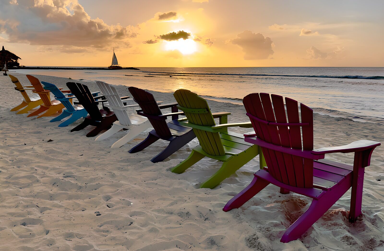 PDGIT8660658: Sedie colorate in spiaggia al tramonto