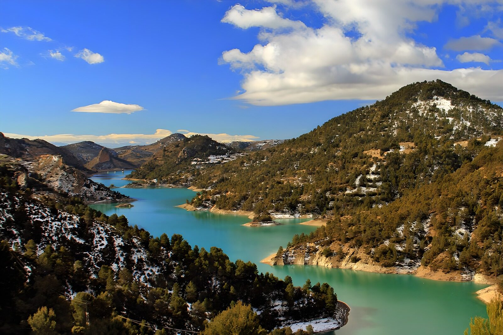 PDGIT6583256: Lago turchese tra boschi e neve
