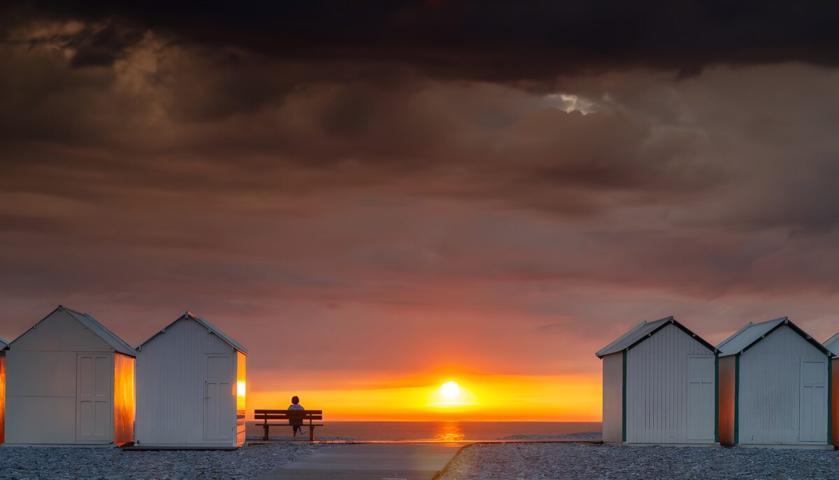 PDGIT5879790: Cabine bianche al tramonto sul mare