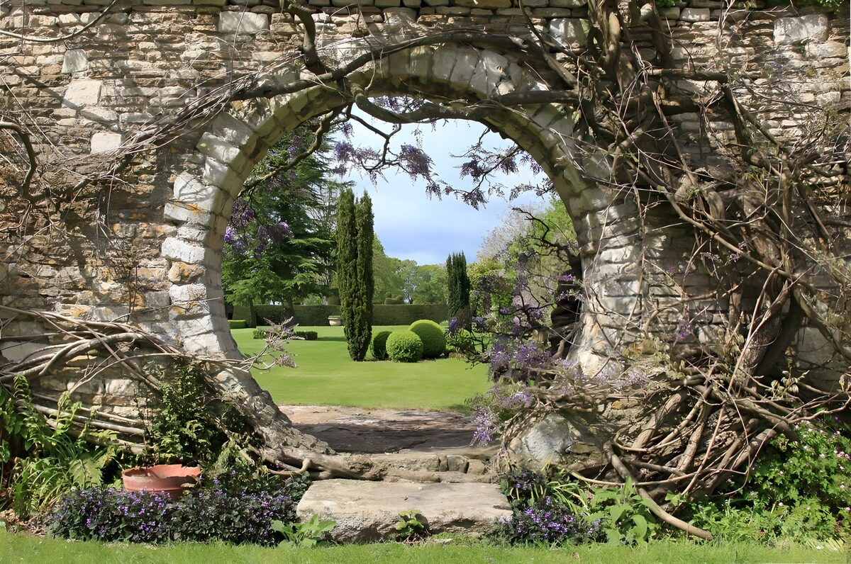 PDGIT7946006: Porta rotonda su un giardino al sole