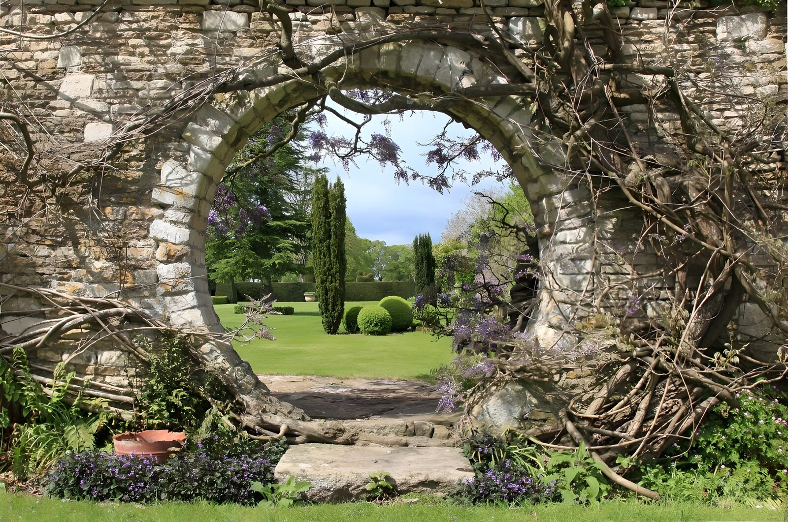 PDGIT7946006: Porta rotonda su un giardino al sole