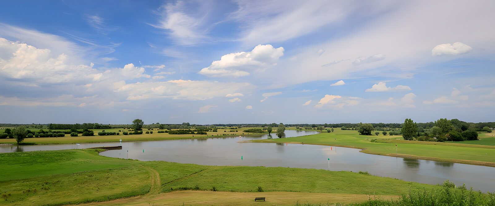 PDGIT8948142: Campo da golf sul lago sotto l’azzurro
