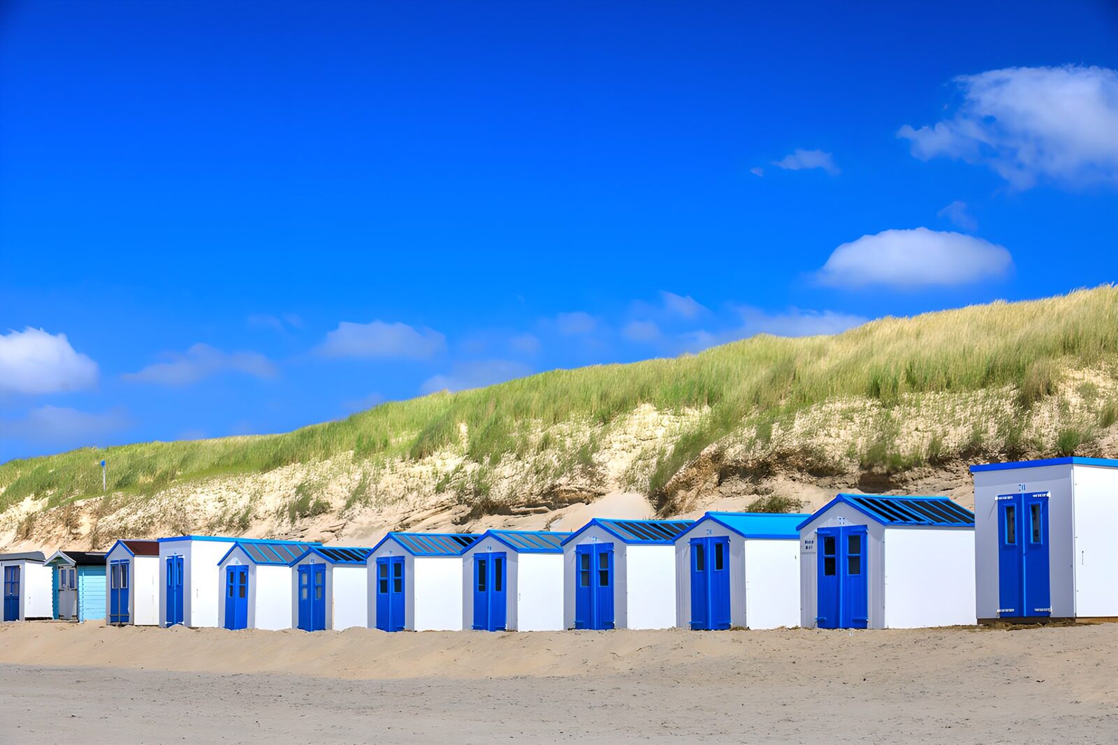 PDGIT6653593: Cabine bianche e blu nella quiete delle dune