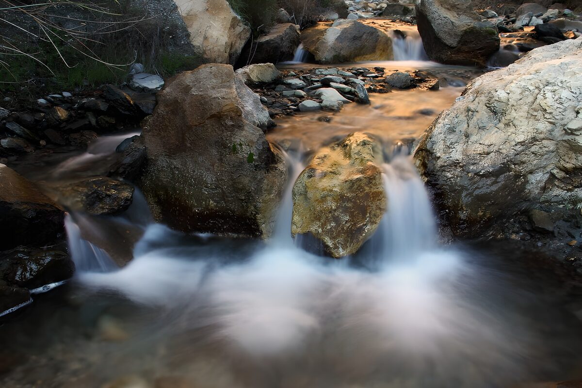 PDGIT1384603: Piccole cascate tra rocce e luce dorata