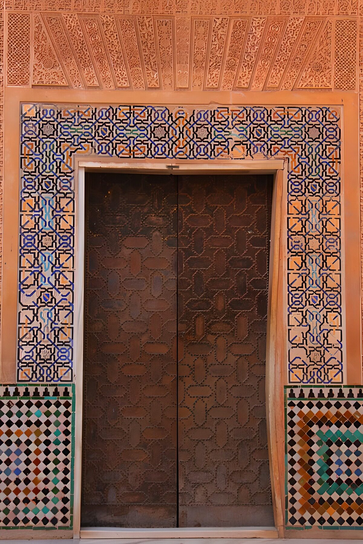 Porta scura tra mosaici e arabeschi