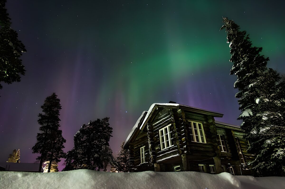 PDGIT7491927: Casa di legno sotto l’aurora boreale