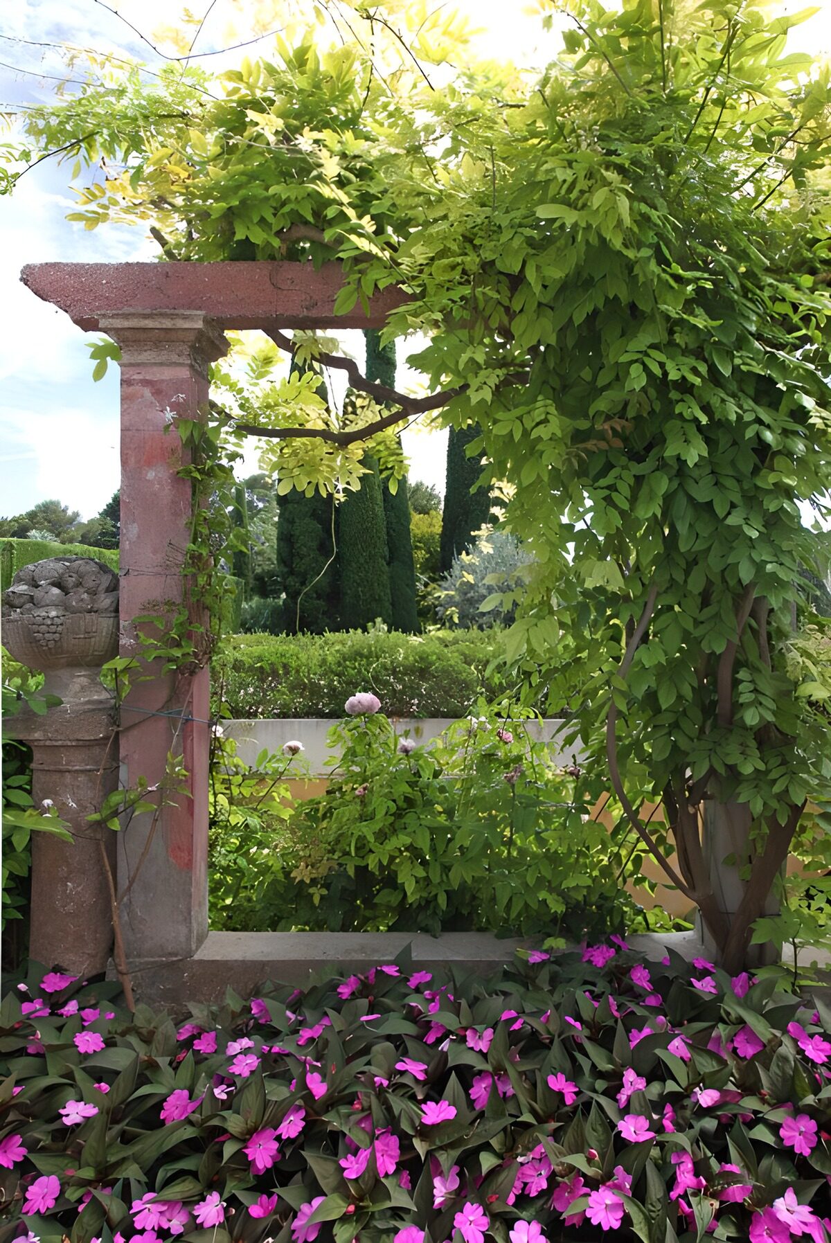 Pergola in pietra tra fiori rosa