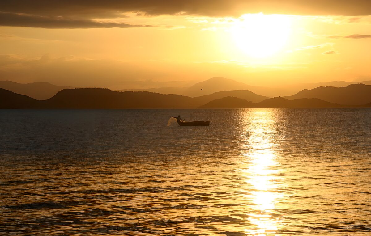 PDGIT4466848: Pescatore in barca al tramonto