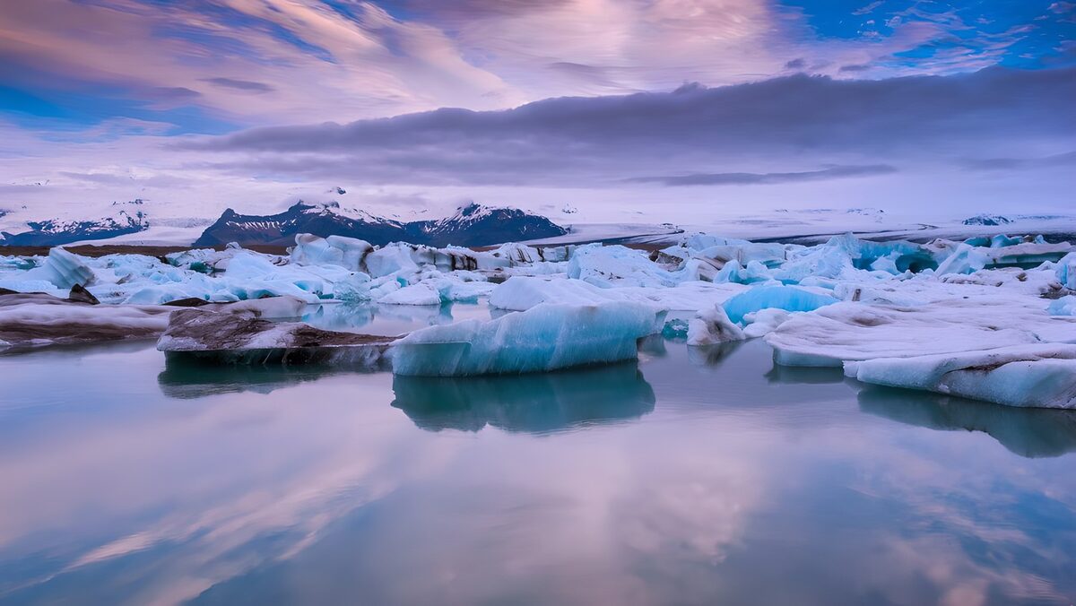 PDGIT1830659: Iceberg e montagne sotto un cielo rosa