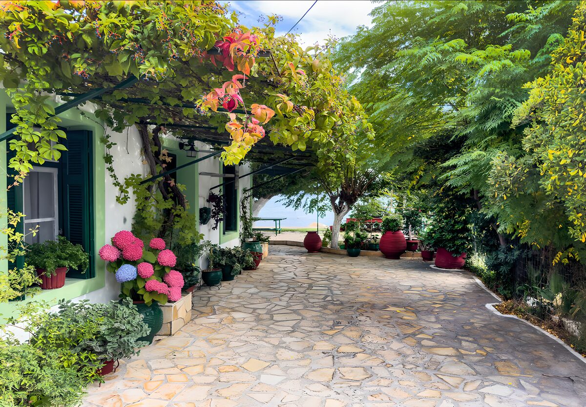 Cortile in pietra tra pergola e ortensie